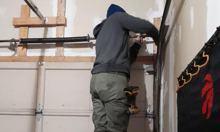 person-repairing-garage-door