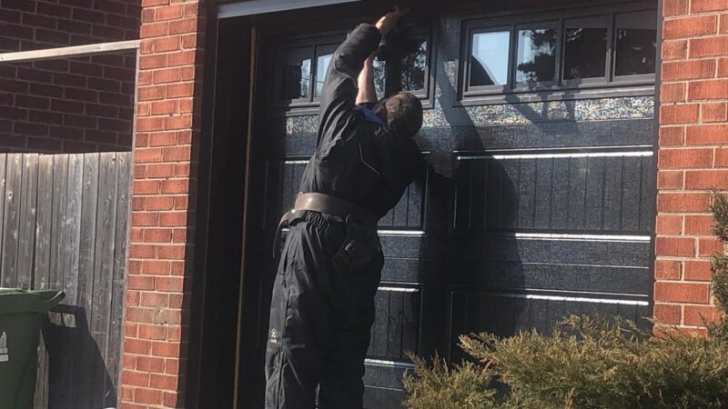 person-repairing-garage-door
